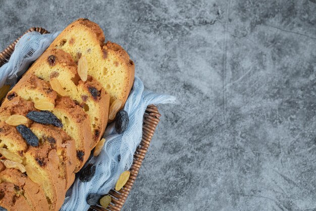 Geschnittener Kuchen auf blauem Tuch auf hölzernem Korb.