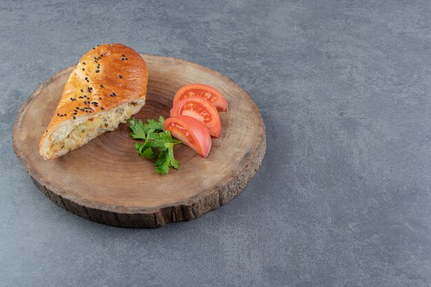 Geschnittenes Gebäck gefüllt mit Käse auf Holzstück.