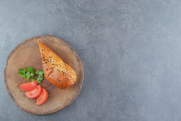 Geschnittenes Gebäck gefüllt mit Käse auf Holzstück.