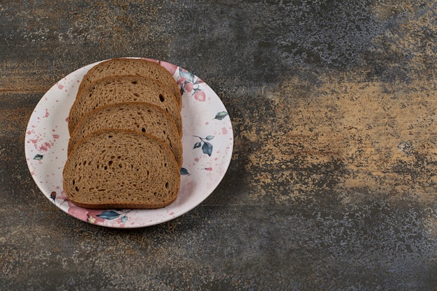 Geschnittenes Roggenbrot auf buntem Teller