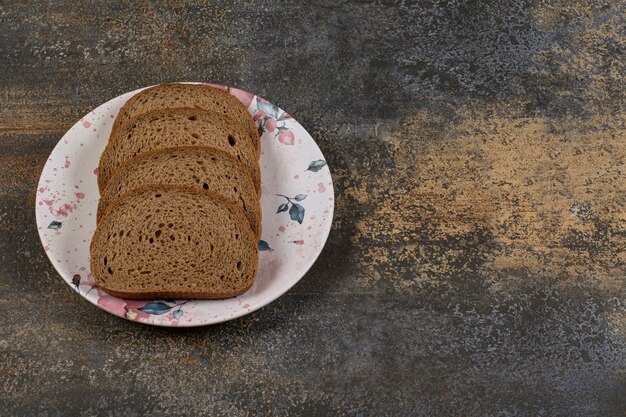 Geschnittenes Roggenbrot auf buntem Teller