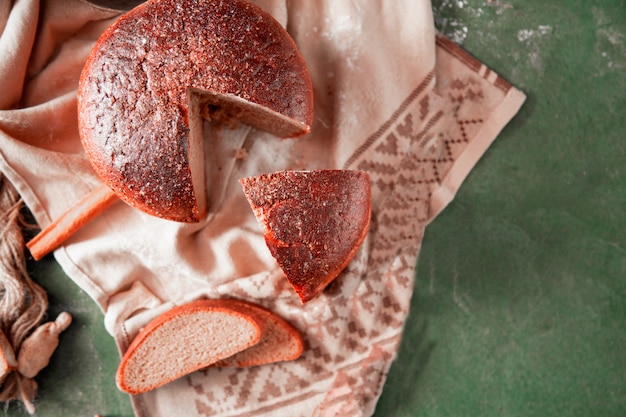 Kostenloses Foto geschnittenes rundes traditionelles brot mit kräutern auf ihm, draufsicht.