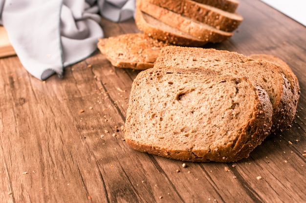 Geschnittenes Toastbrot auf einem Holztisch auf dem blauen Handtuch