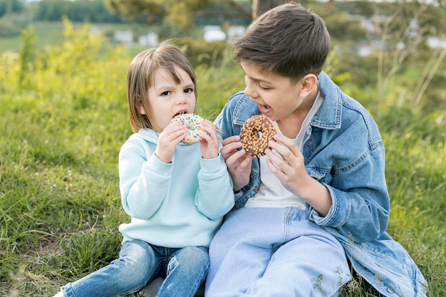 Geschwister essen gemeinsam Donuts