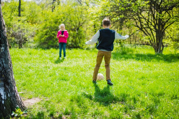 Geschwister Fußball spielen im Freien