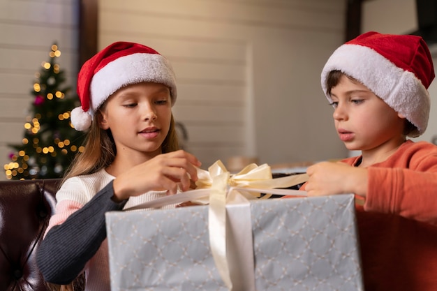 Geschwister öffnen gemeinsam ein Weihnachtsgeschenk