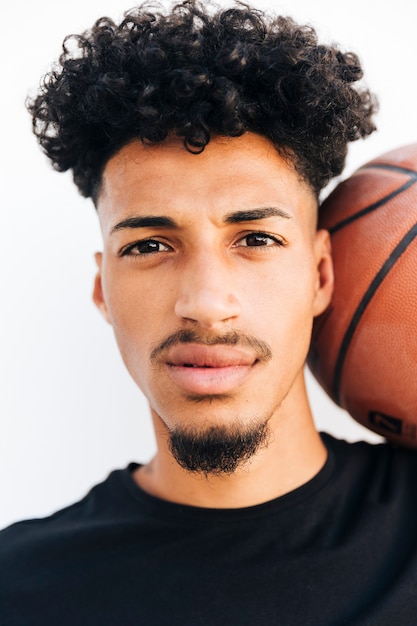 Gesicht des schwarzen jungen Mannes mit Basketball