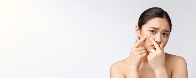 Gesicht Hautproblem junge Frau unglücklich berühren ihre Haut isoliert Konzept für die Hautpflege asiatisch