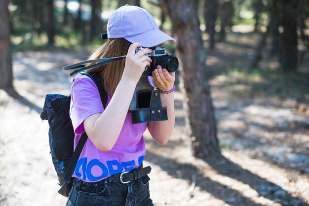 Gesichtslose Frau, die Fotos im Wald macht