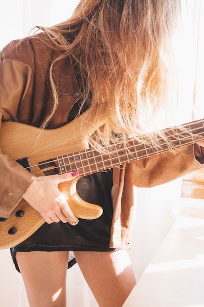 Kostenloses Foto gesichtslose frau mit gitarre