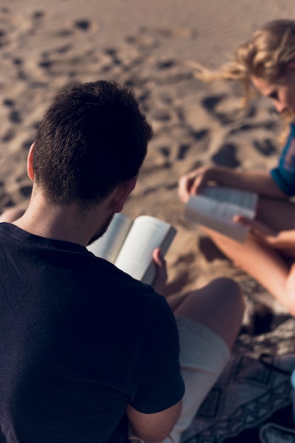 Gesichtslose Paarlesung auf Strand