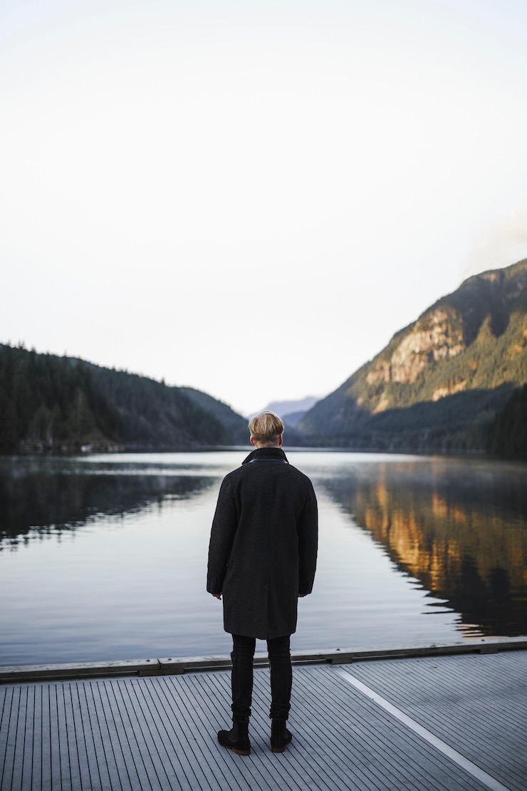 Kostenlose Foto gesichtsloser mann, der see betrachtet