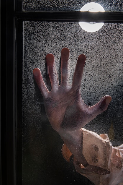 Gespenstische Zombiehand an einem Fenster