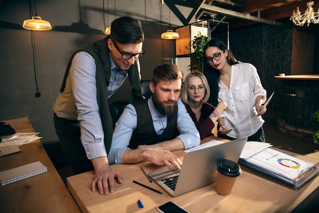 Gespräche. Kollegen arbeiten in einem modernen Büro mit Geräten und Gadgets während kreativer Besprechungen zusammen.