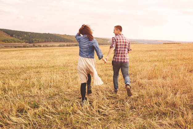 Gestalten Sie Porträt von den jungen schönen stilvollen Paaren landschaftlich, die den Spaß im Freien sinnlich und haben