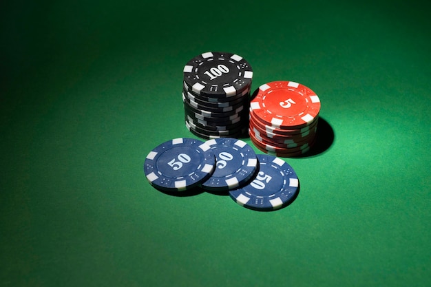 Gestapelte Casino-Token auf grünem Hintergrund