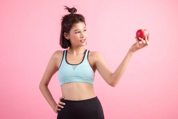 Gesunde Frau des Sports, die einen roten Apfel anhält