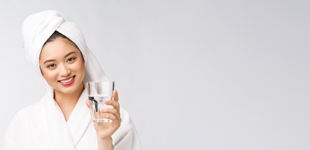 Gesunde junge schöne Frau Trinkwasser Schönheit Gesicht natürliches Make-up isoliert auf weißem Hintergrund