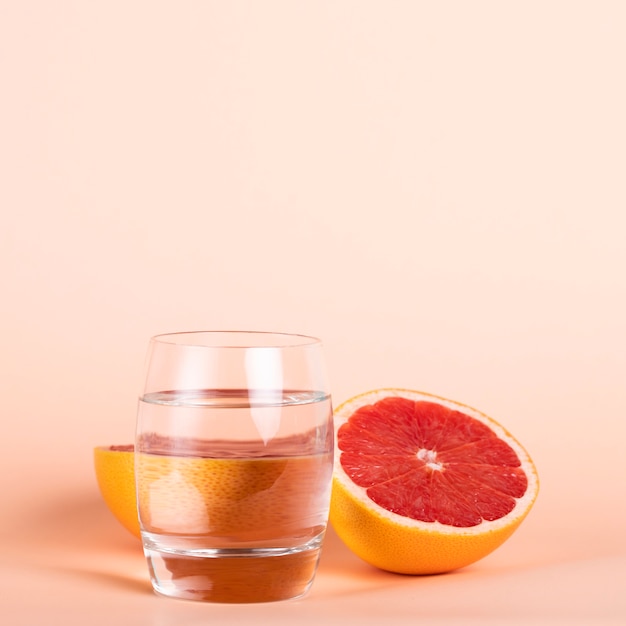 Kostenloses Foto gesunde köstliche frucht mit glas wasser