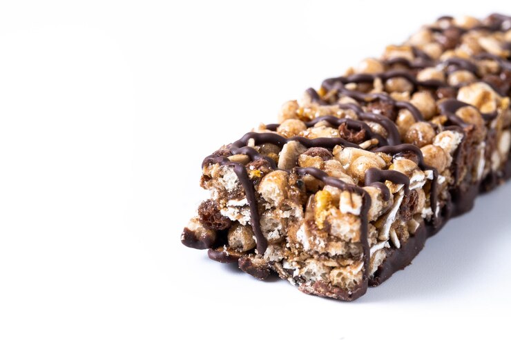 Kostenlose Foto gesunde muesli-riegel mit nüssen und samen auf weißem hintergrund