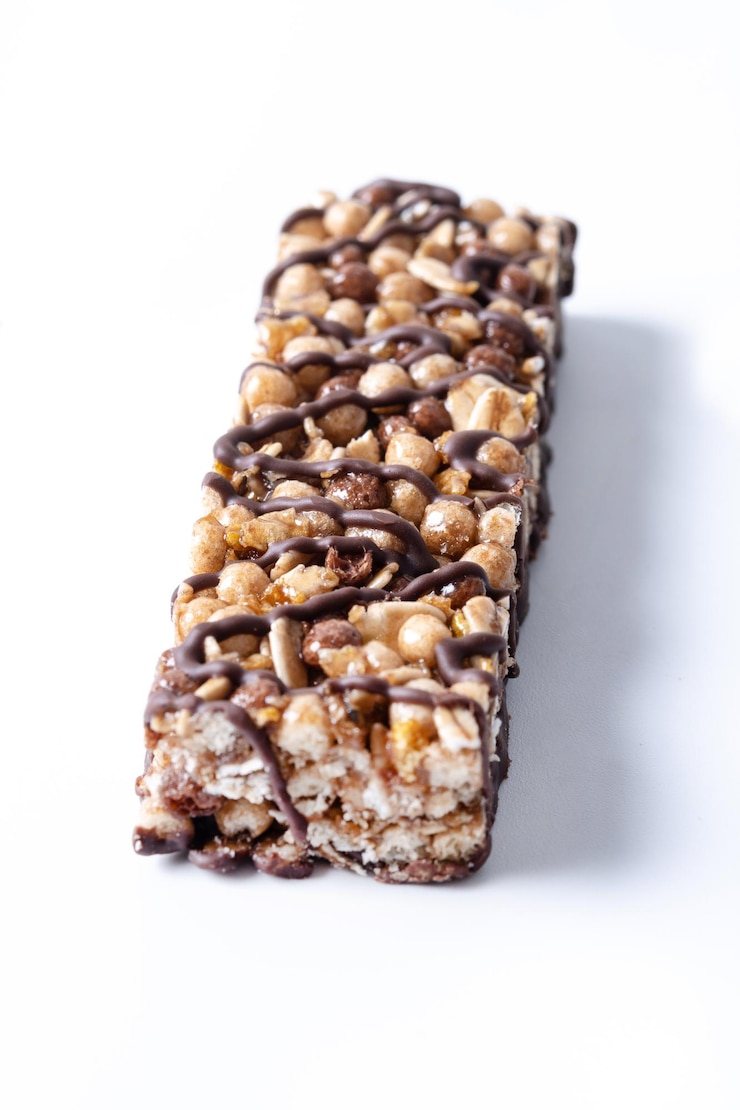 Kostenlose Foto gesunde muesli-riegel mit nüssen und samen auf weißem hintergrund