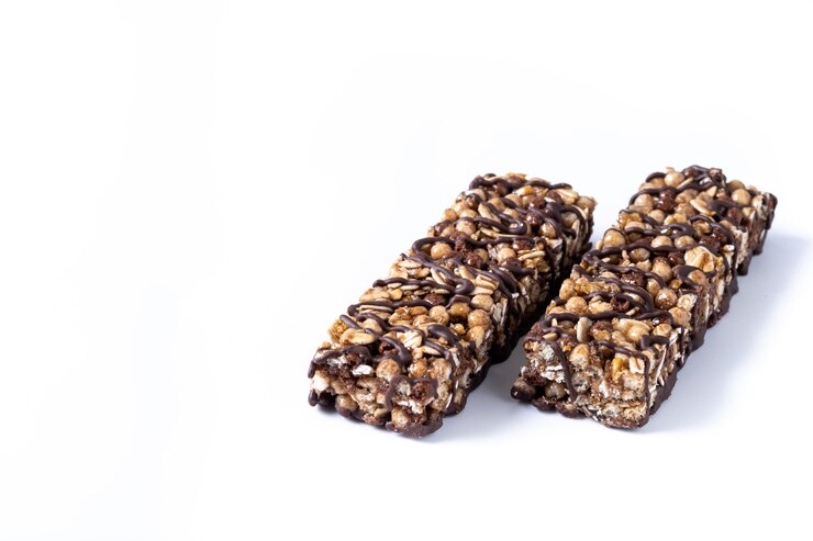 Kostenlose Foto gesunde muesli-riegel mit nüssen und schwarzer schokolade auf weißem hintergrund