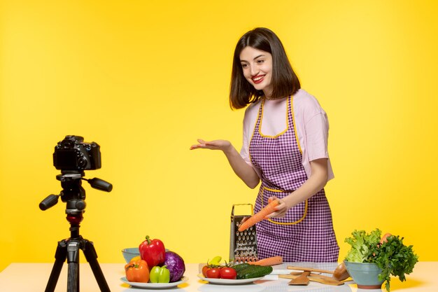 Gesunder Fitness-Koch eines Food-Bloggers, der ein Video für soziale Medien aufnimmt, in dem Karotten zerkleinert werden