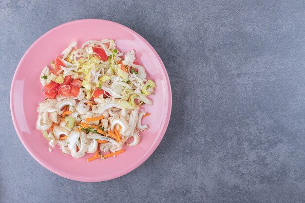 Gesunder frischer Salat auf rosa Salat.