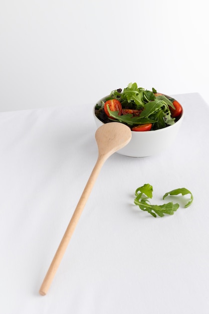 Kostenloses Foto gesunder salat in der weißen schüssel auf einem weißen tisch
