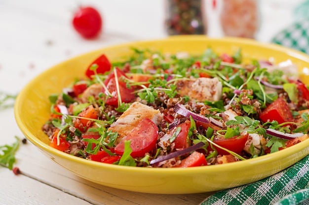 Gesundes Abendessen. Salatschüssel Mittagessen mit gegrilltem Hähnchen und Quinoa, Tomaten, Paprika, roten Zwiebeln und Rucola