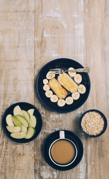 Gesundes frisches Obst; Müsli und Kaffeetasse auf hölzernen strukturierten Hintergrund