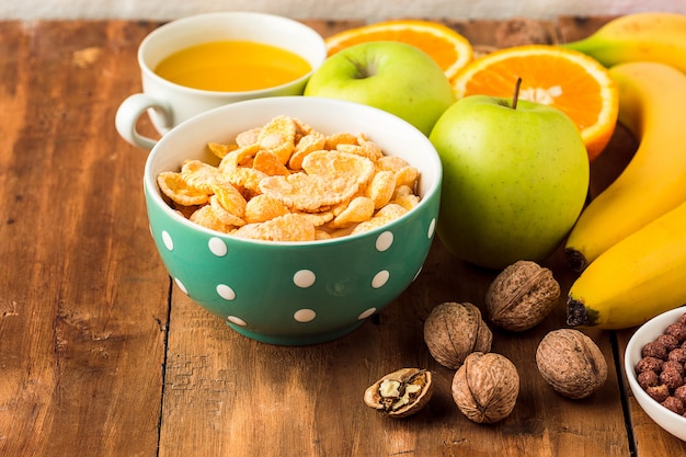 Gesundes hausgemachtes frühstück mit müsli, äpfeln, frischen früchten und walnüssen