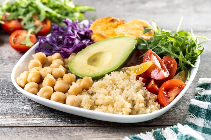 Kostenlose Foto gesundes salat mit avocadellettucetomat und kichererbsen auf einem holztisch
