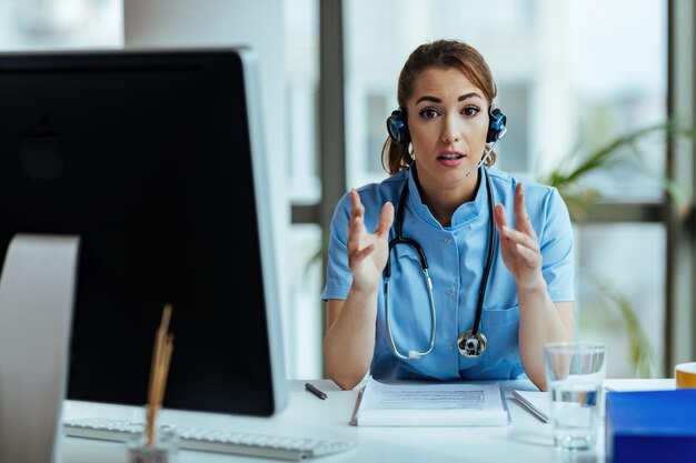 Gesundheitsexperte trägt Headset, während er im Callcenter arbeitet und Patienten Anweisungen gibt