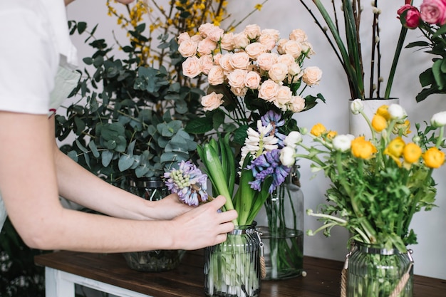 Getreidefrau, die Blumen im Shop anordnet