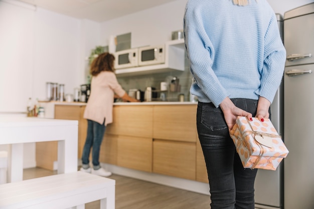 Kostenloses Foto getreidefrau, die überraschung für mutter in der küche macht