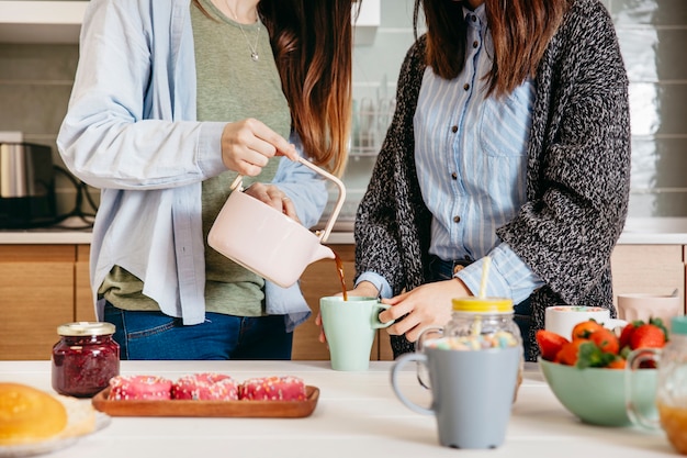 Getreidefrauen, die Tee in Küche gießen