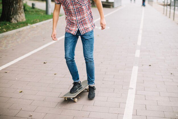 Getreidejugendlicher, der auf Fahrradweg Skateboard fährt