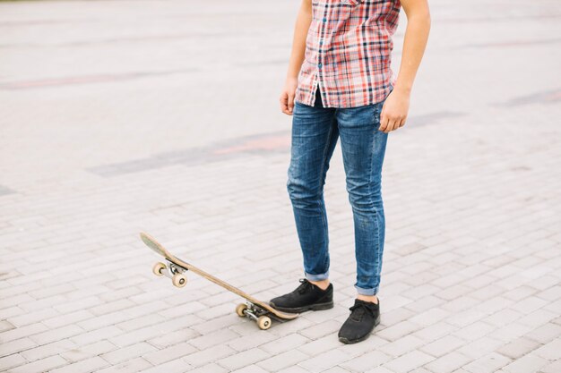 Getreidejugendlicher, der auf Skateboard tritt