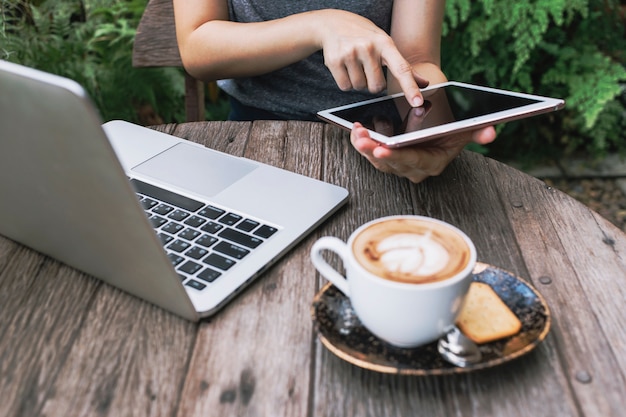 Getreideperson, die Tablette im Garten durchstöbert