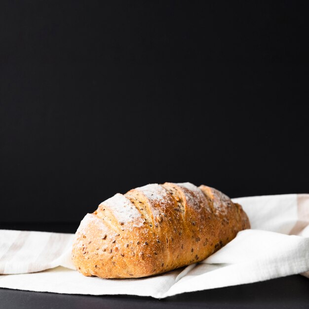 Getrenntes frisches Brot auf schwarzem Hintergrund und Tuch