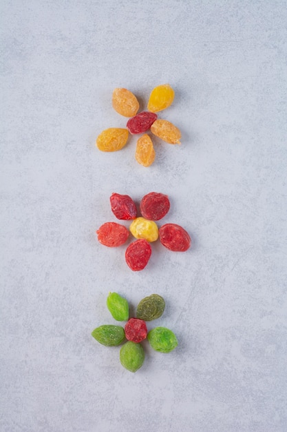 Kostenloses Foto getrocknete mehrfarbige kirschen und beeren auf betonoberfläche.