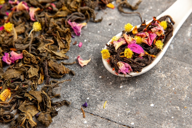 Getrockneter fruchtiger Tee der Vorderansicht getrocknet frisch mit Blumengeschmack auf dem grauen rustikalen Raum