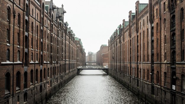 Gewässer zwischen braunen Betongebäuden in Hamburg, Deutschland während des Tages