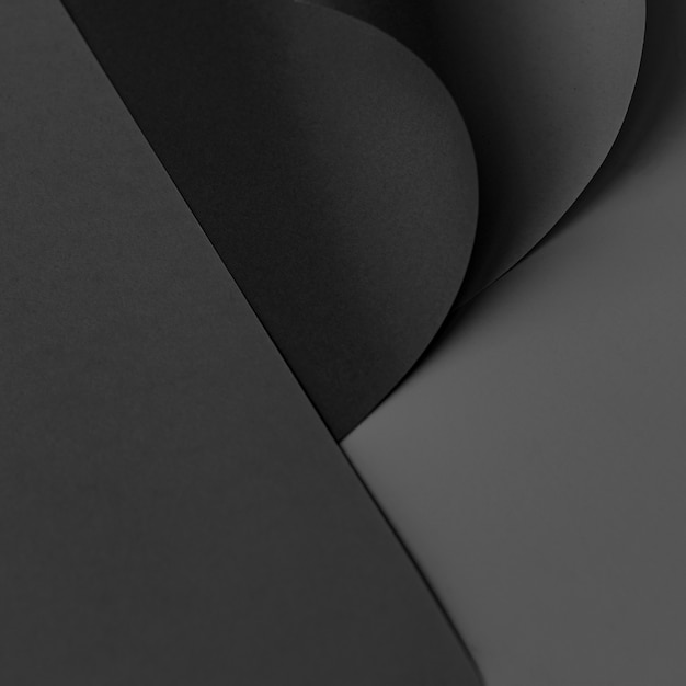 Gewelltes schwarzes Kartenpapier auf dunkelgrauem Hintergrund