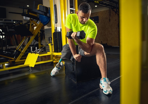 Gewichte. Behindertentraining in der Turnhalle des Rehabilitationszentrums, Üben. Aktiver Mann mit Behinderung. Konzept für einen gesunden und aktiven Lebensstil, Motivation, Konzentration, Inklusion und Vielfalt.