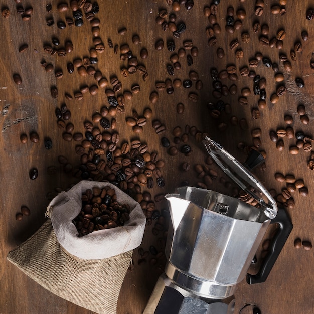 GeysirKaffeemaschine und Sack mit zerstreuten Bohnen