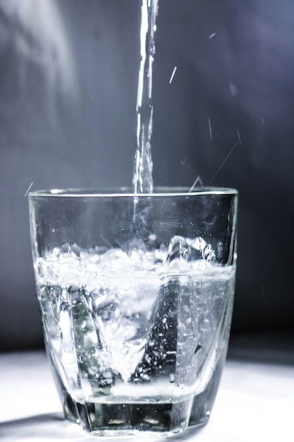 Gießen von Wasser in Glas