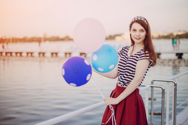 Girl posiert mit Ballons in einem Hafen