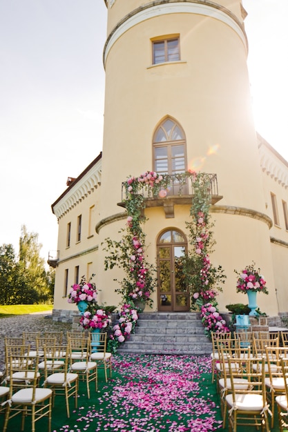 Girlanden von Grün und rosa Blüten hängen vom Balkon über die Treppe